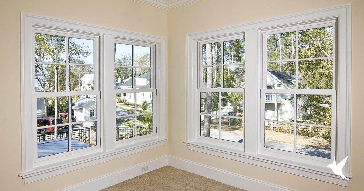 A white room with double hung windows and white trim.