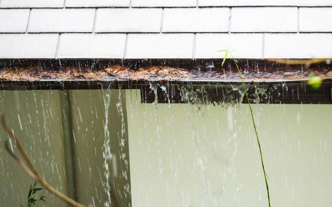 gutter-guards-reduce-risk-for-water-damage - A house with a roof and water coming out of it.