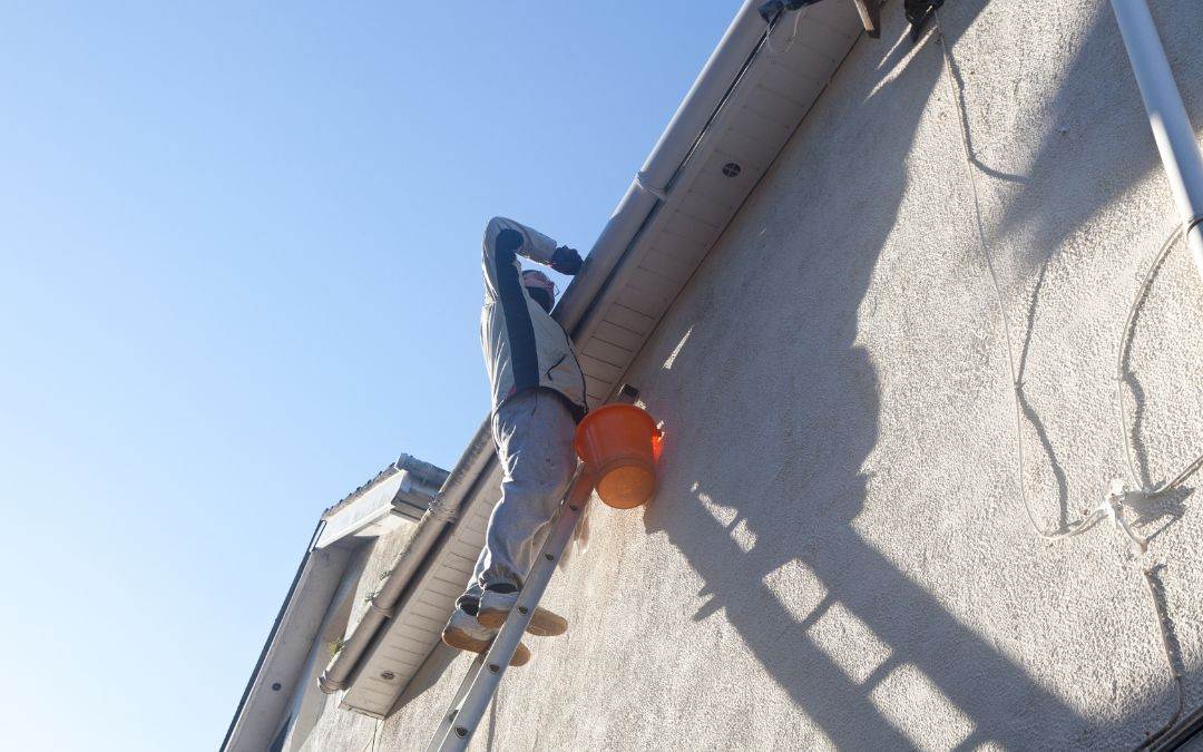 why-get-gutter-guards-gutter-guards-improve-safety - A man climbing a ladder on the side of a building.